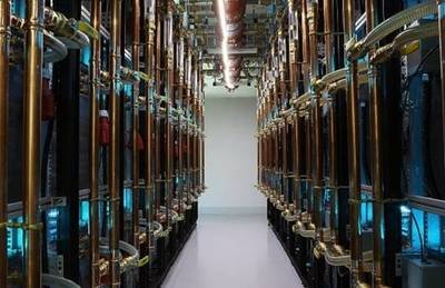 A wide shot of a mining farm, showing rows of mining rigs and the scale of operations required for cryptocurrency mining.